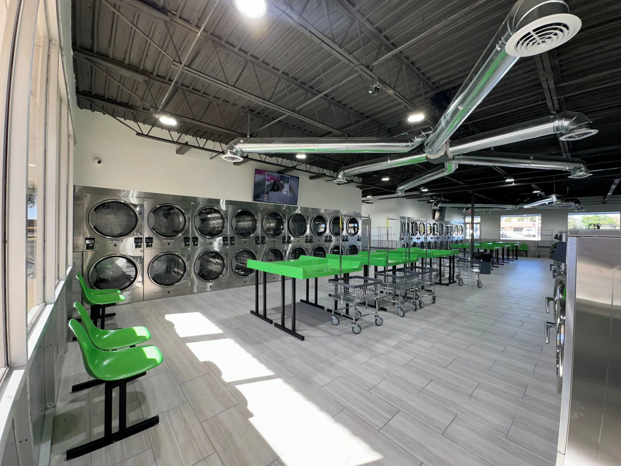 Inside the Clovis Dustoff laundromat — green folding tables and Huebsch machines
